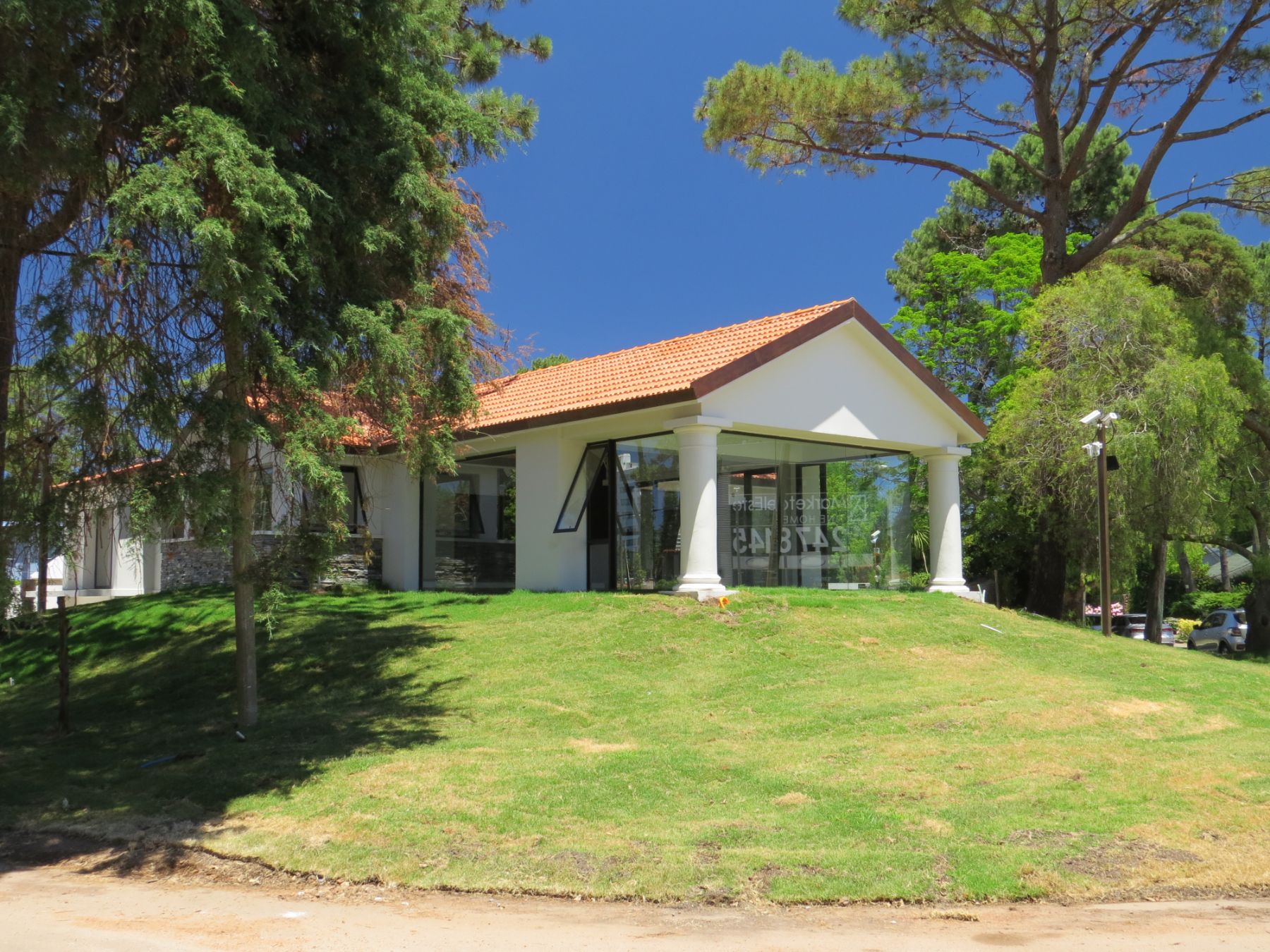 Es una fotografía tomada desde la proa en la que se ven las dos columnas redondas, varios ventanales y un tejado a dos aguas del edificio. Todo esto tomado desde un ángulo en diagonal, que permite apreciar el costado de la construcción, en el que se aprecian algunos muros de piedra.